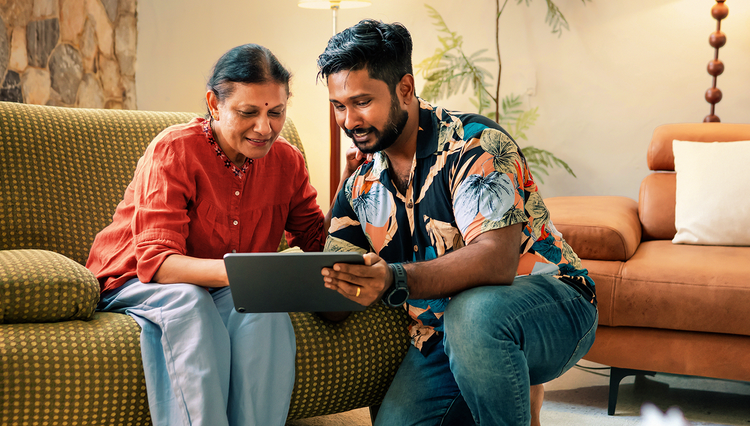 A woman and her son look at a tablet